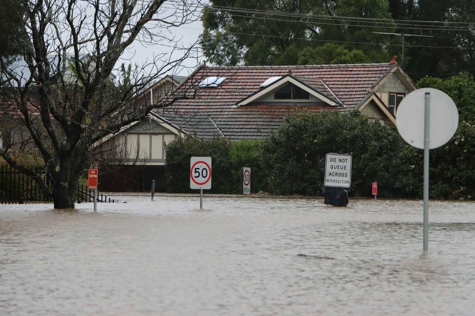a house with a sign in front of it, flood & home